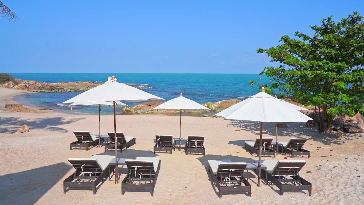 화창한 날 터키 마르마리스(marmaris)에 있는 열대 해변의 파라솔 아래 데크 의자가 있는 빈 해안가 해변 라운지를 마련했습니다.