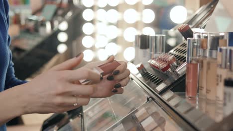 woman trying on lipstick in a cosmetics store