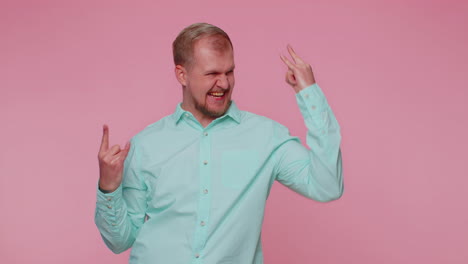 overjoyed happy man showing rock n roll gesture by hands, cool sign, shouting yeah with crazy face