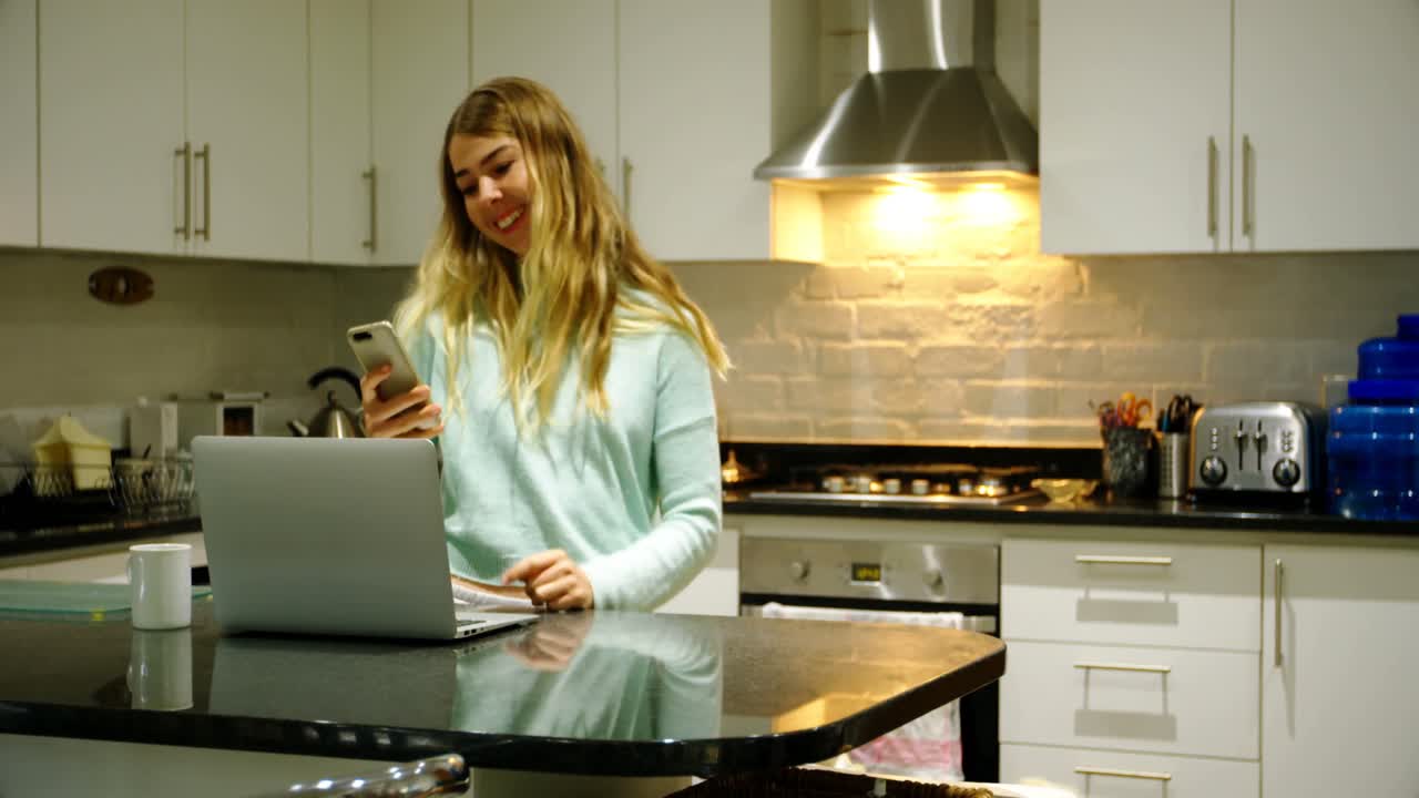 Donna che si scatta un selfie con il suo cane in cucina 4k