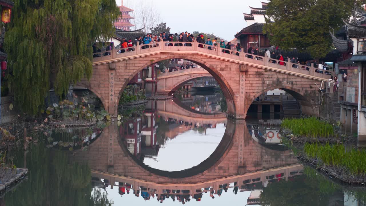 Crowded Stone Bridge Over Canal in Ancient Chinese Town