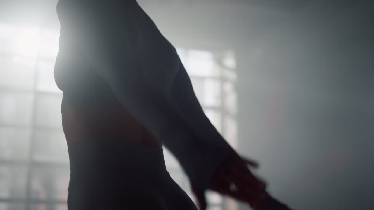 chica activa saltando en el gimnasio moderno. mujer enérgica haciendo sentadillas con saltos