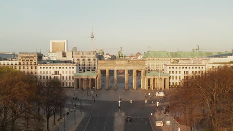 AERIAL:-Over-Empty-Brandenburger-Tor-in-Berlin,-Germany-due-to-Coronavirus-COVID-19-Pandemic-in-Sunset-Light