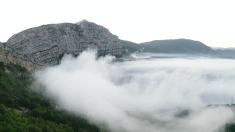 mountain and clouds seen from the drone in rear traveling