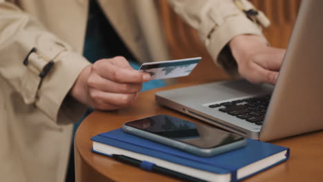 kaukasische studentin, die im freien auf einem laptop online einkaufen.