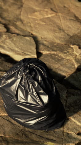 black trash bag on a stone ground