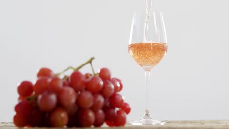 Nahaufnahme-Von-Roten-Trauben-Und-Wein,-Die-Ins-Glas-Fallen