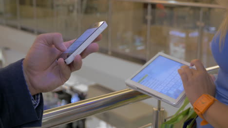 persone che usano smartphone e pad nel centro commerciale