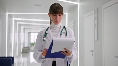 doctor reviewing medical records in a modern hospital hallway