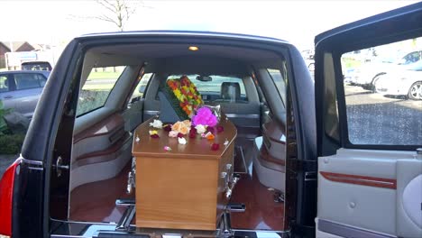 closeup shot of a funeral casket in a hearse or chapel or burial at cemetery