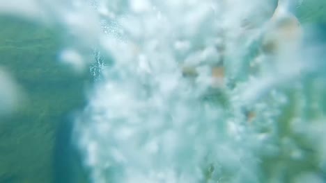 young-man-deep-diving-in-clear-blue-water-at-day-from-different-angle