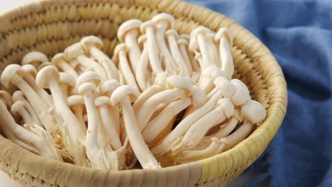 fresh white mushrooms in a straw basket