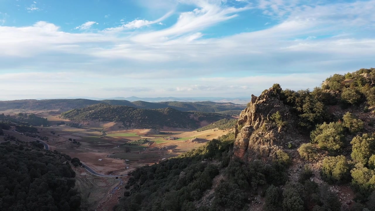 Panorama aéreo cinematográfico de drone de um mirante rochoso dramático sobre vastos vales e paisagens selvagens no Médio Atlas, Marrocos, ideal para projetos de aventura de viagem e documentários.