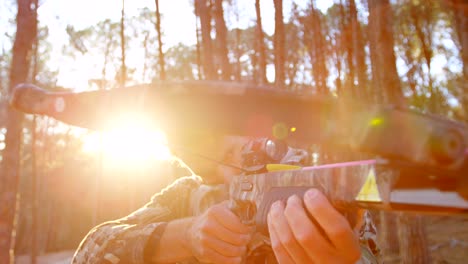 man aiming with compound bow in the forest 4k