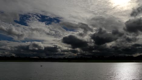 time lapse of a dramatic sky at dusk, with normal speed for the lake