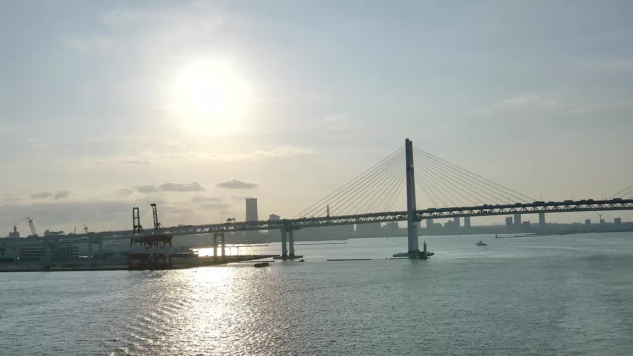 A wide shot of the Yokohama Bay Bridge taken from the cruise ship top deck, capturing ocean views and towering bridge spans