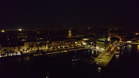 Vista-Aérea-Nocturna-De-Split,-Croacia:-Luces-De-La-Ciudad-Y-Tapiz-Urbano-En-Expansión