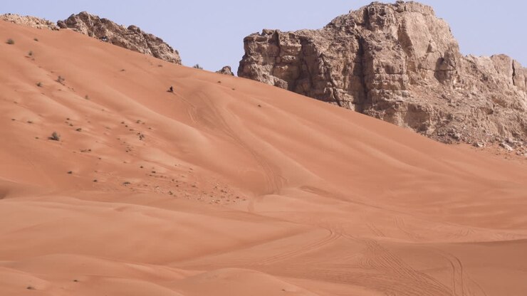 Avventura estrema in moto sulle dune dorate del deserto a Fossil Rock, Sharjah, Emirati Arabi Uniti.