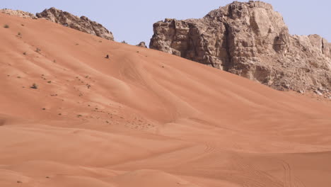 aventura extrema de andar en motocicleta en las dunas doradas del desierto en roca fósil en sharjah, emiratos árabes unidos