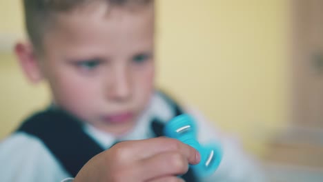 little boy looks at turning spinner on blurred background