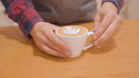 Barista-Pone-En-El-Mostrador-Una-Taza-De-Capuchino-Con-Arte-Latte