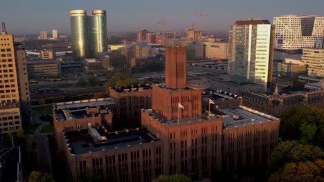 Sideways-pan-showing-sunrise-illuminating-the-Inktpot-building-with-UFO-resting-on-its-facade-flanked-by-modern-skyscraper-buildings