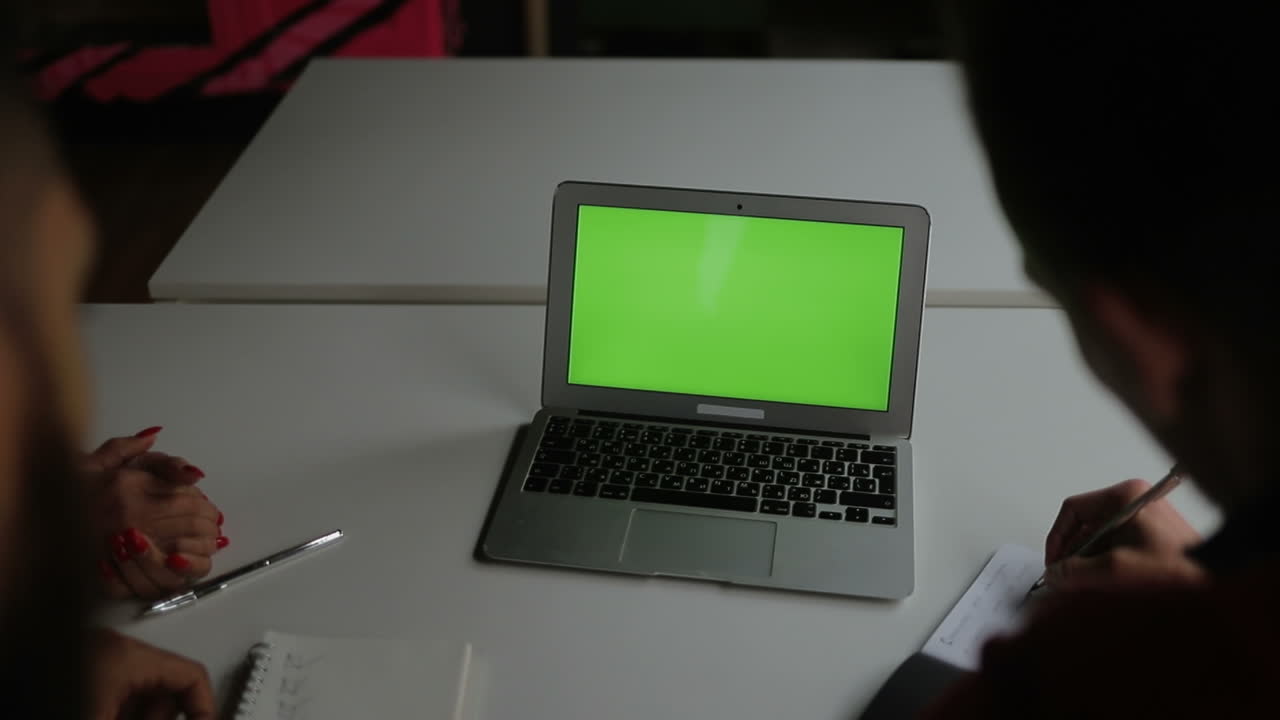 grupo de jóvenes sentados a la mesa con una computadora portátil.