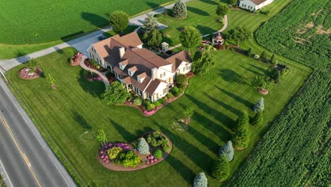 Sunset-on-large-American-farmhouse-with-beautiful-landscaping