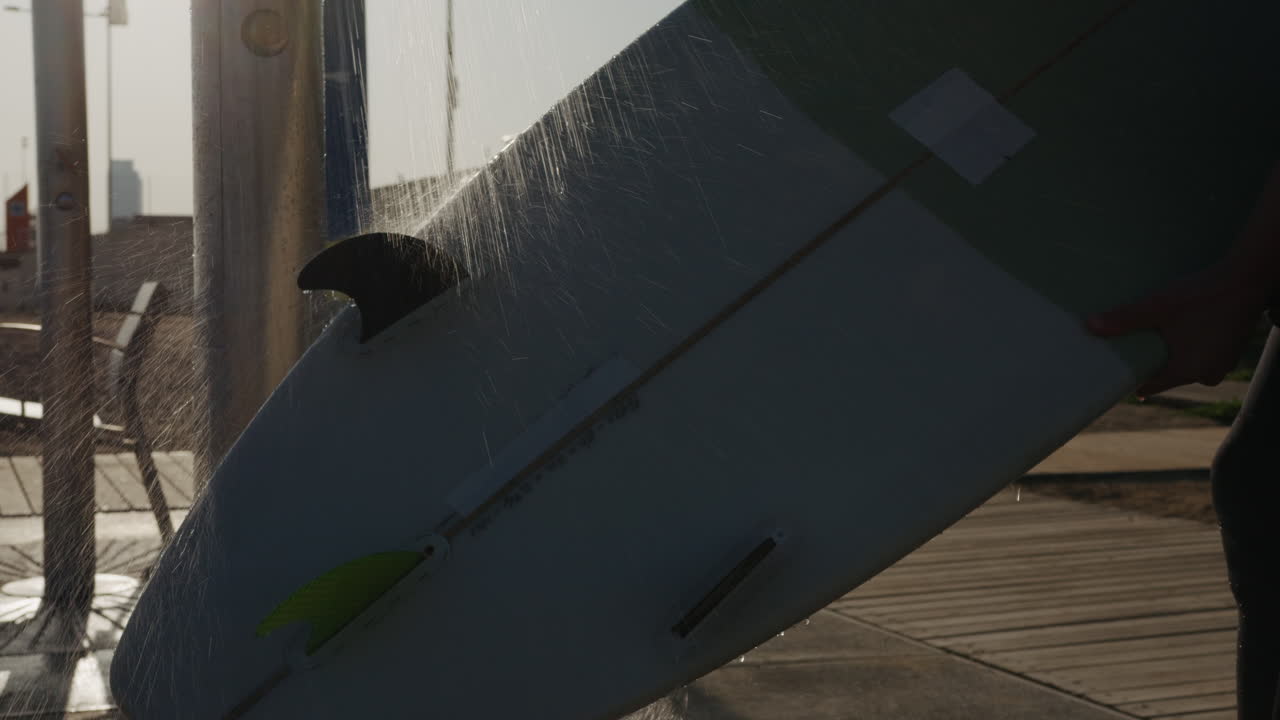 Surfer man walking to the beach at sunset preparing for surfing training and search for waves in Barcelona, spain, water, ocean exercise in sea with board, athletic male holiday or travel in vacation