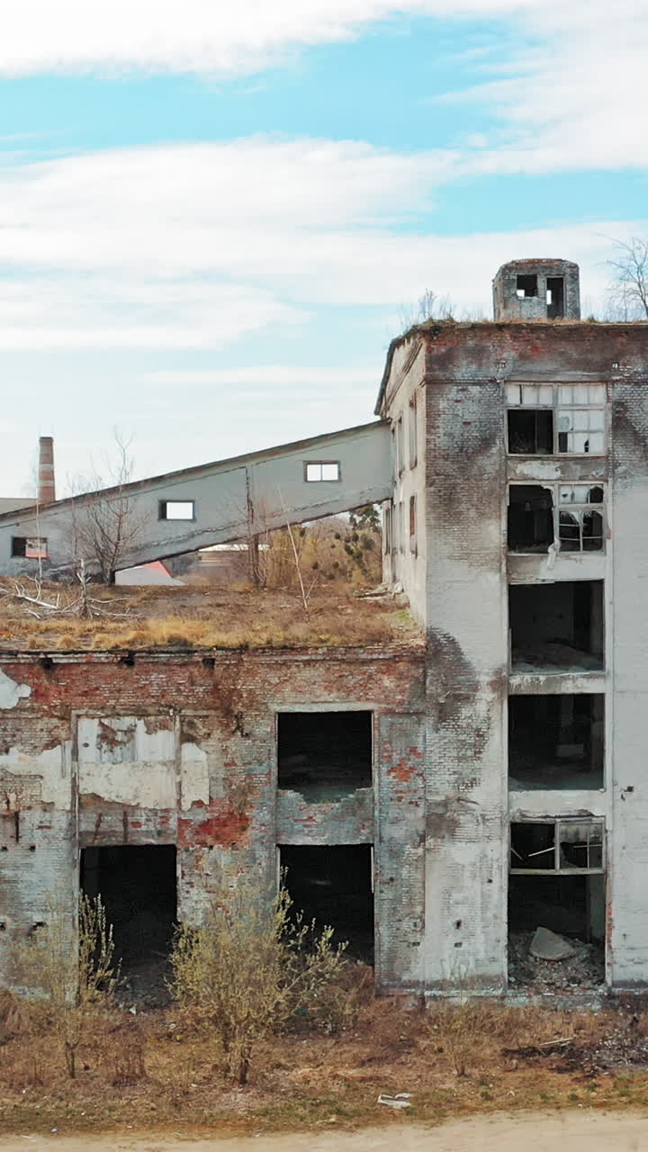 Front facade of abandoned building. Old factory shows the post industrial plight with broken windows Vertical video
