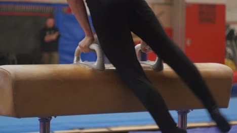 person does gymnastics tricks on the pommel horse