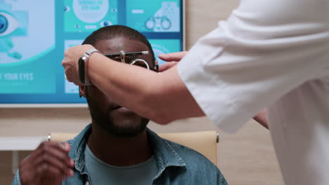 el médico le pone lentes al paciente.