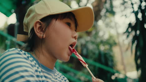 young girl enjoying a lollipop in a park