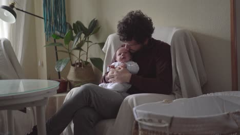 papá abrazando al bebé recién nacido en el sillón en casa