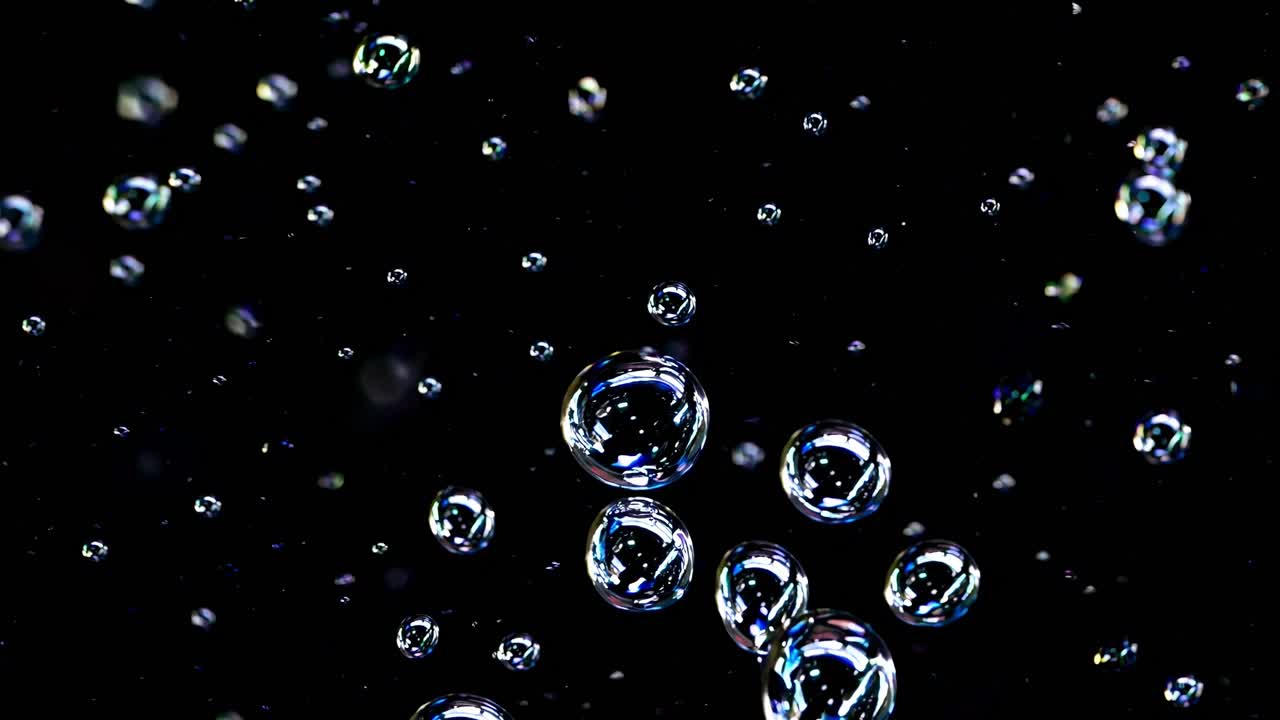 burbujas de agua flotando con gracia contra un telón de fondo oscuro, revelando dinámicas visuales hipnotizantes de luz, transparencia y movimiento fluido con elegancia etérea