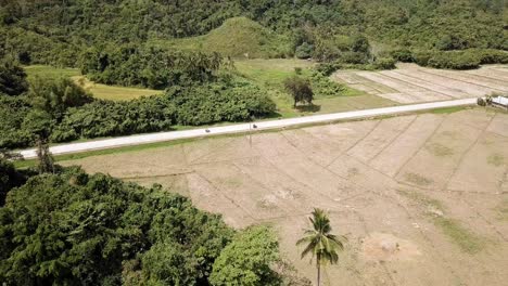 4K-Aerial-Drone-View-People-Riding-on-Motorcycle-in-a-Tropical-Destination-Through-a-Forest-Jungle,-El-Nido,-Palawan,-Philippines