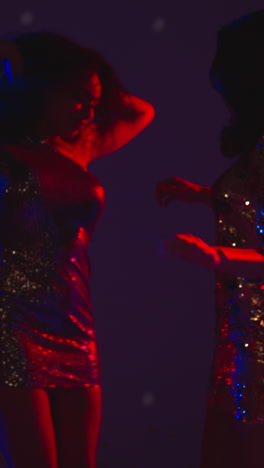 Vertical-Video-Of-Two-Women-In-Nightclub-Bar-Or-Disco-Dancing-With-Sparkling-Lights-In-Background-1