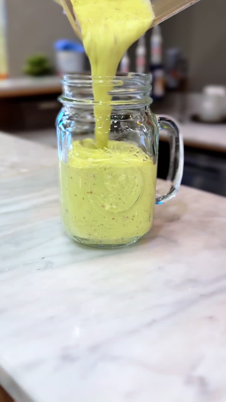 Thick avocado smoothie poured into a clear glass jar. Captured in crisp 4K vertical format. Great for health, nutrition, food blogs, or wellness brand content.