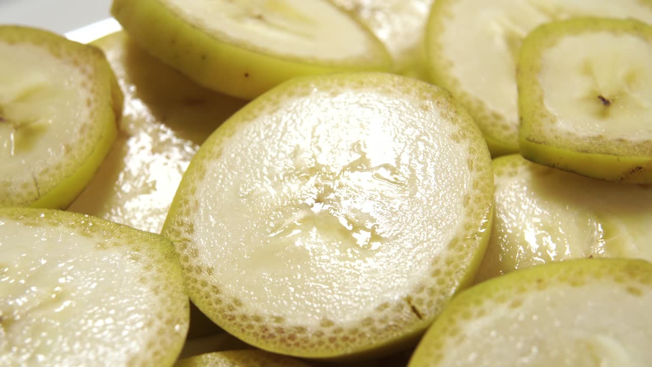 질을 벗기지 않은 은 바나나, 질이 있는 노란색 과일 조각을 회전시니다.