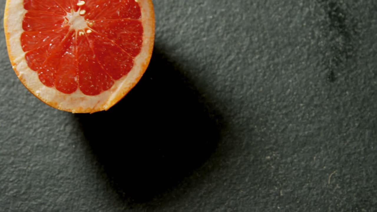 Pompelmo dimezzato su sfondo grigio 4K