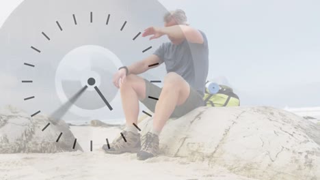 Caucasian-senior-man-hiking-in-countryside,-taking-a-rest,-over-fast-moving-clock-face