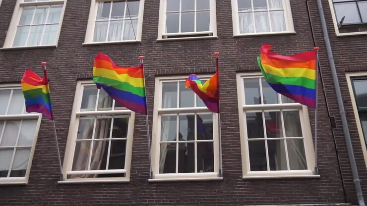 Rainbow flag waving in the wind on a brick building