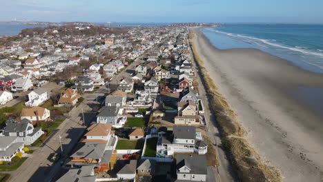 Reserve-pull-back-aerial-footage-over-beach-neighborhood,-Kenberma,-Hull-MA