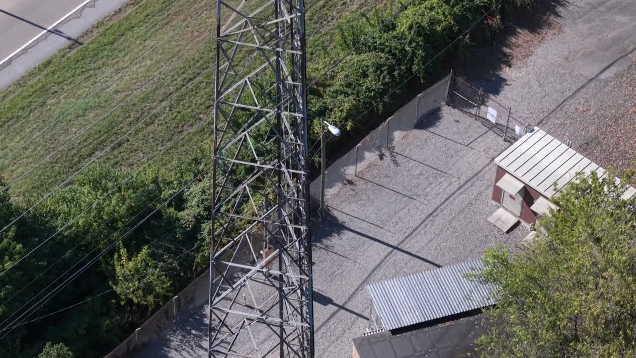 Cellular tower beside a rural highway - ascending from the base to the top in this aerial reveal