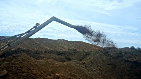 bent metal pipe produces the dirty flow. ground piles around. production of oil and gas.