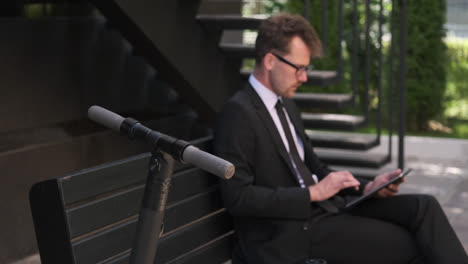 businessman working on tablet outside
