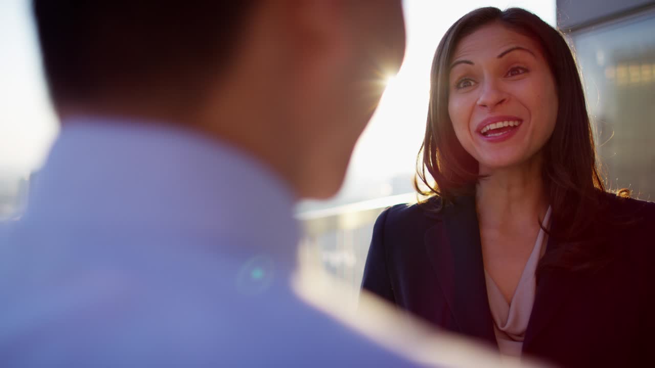 una mujer hispana y un hombre asiático bebiendo café.