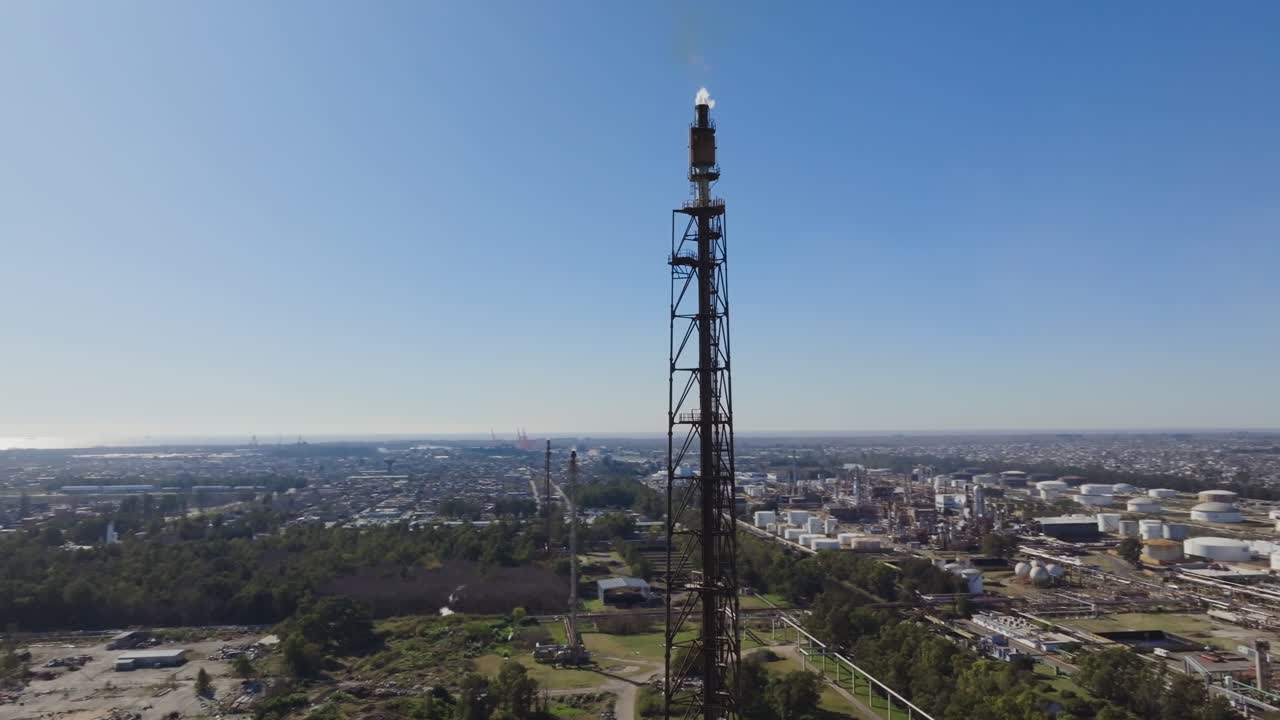 Drone aerial of refinery site with flare stack and energy storage tanks