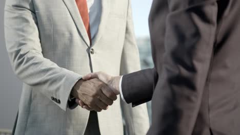 partial view of business people shaking hands outdoor