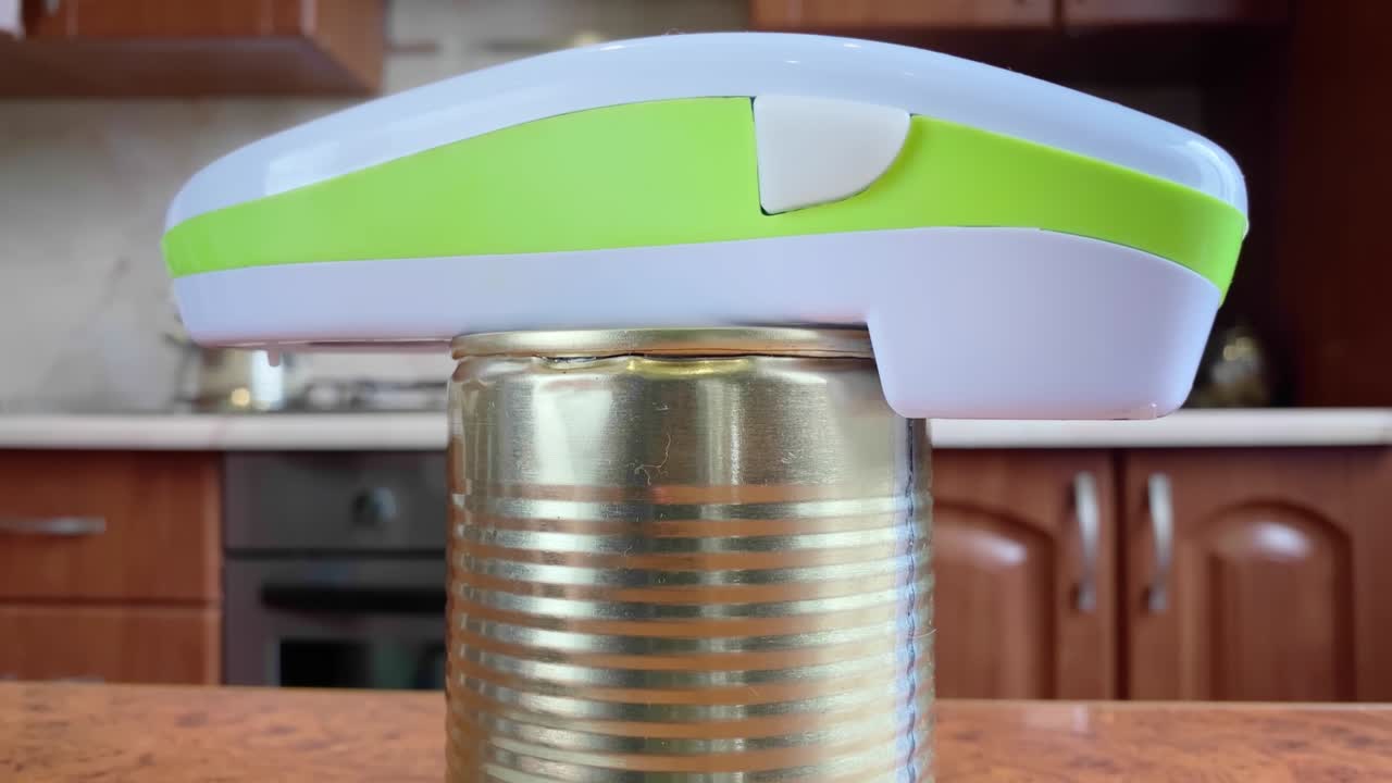 Electric can opener and canned goods on kitchen table